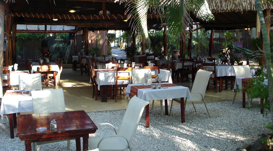 Une partie de la salle de restaurant vue de la terrasse sur plage